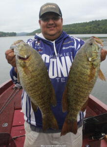 Author Mike Iovino holds up two big smallmouth bass he caught in the fall fishing around suspended b