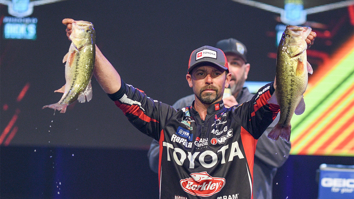 professional angler mike iaconelli holds two bass