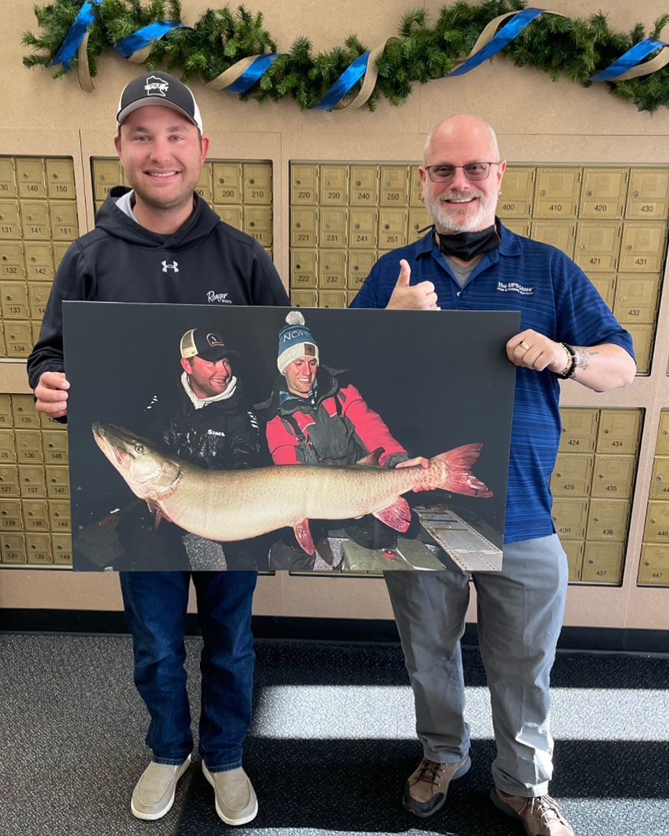 Randy and Nolan holding up a big print of the catch