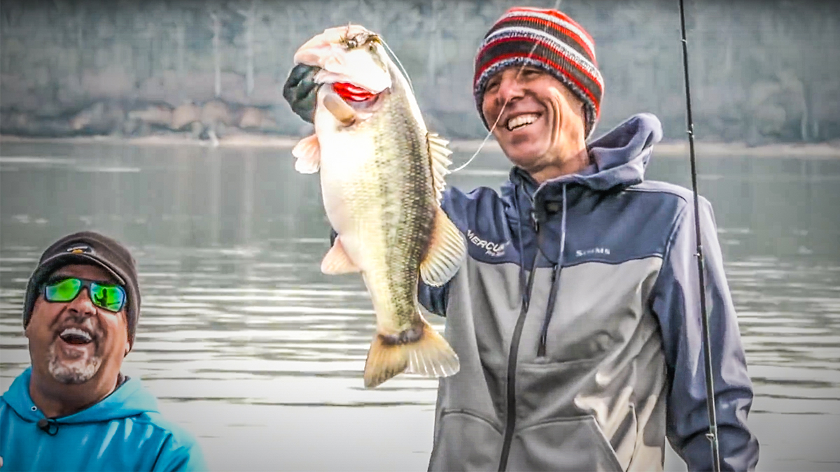 professional angler aaron martens holding a big bass with mark zona smiling
