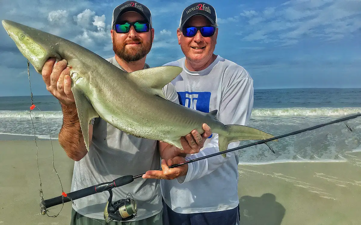 Walker smith and father landing shark from beach