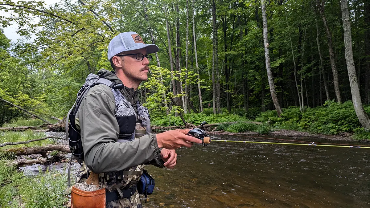 Hobie Wan Kenobi stream fishing holding a rod with the Daiwa Tatula BF TW 70 reel