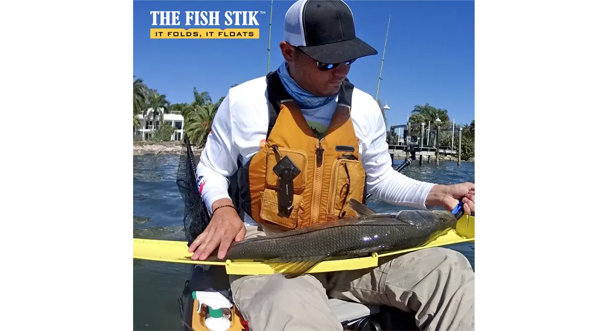 Fish Stik ad - angler measuring a large fish using the fish stik bump board