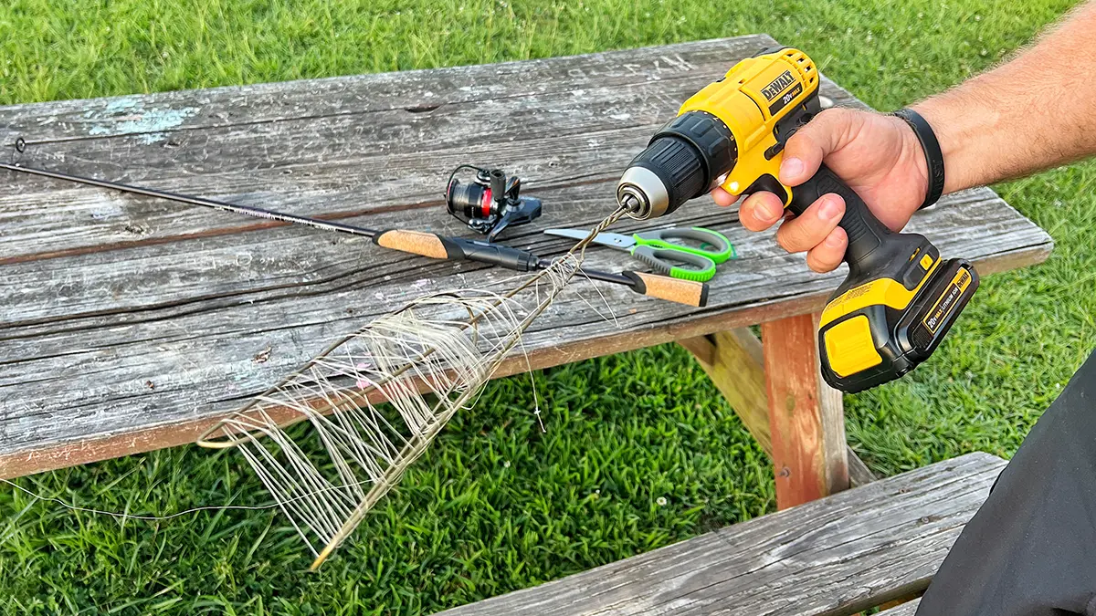 Removing old line from a spinning reel using a drill with an old wire hanger attached to it