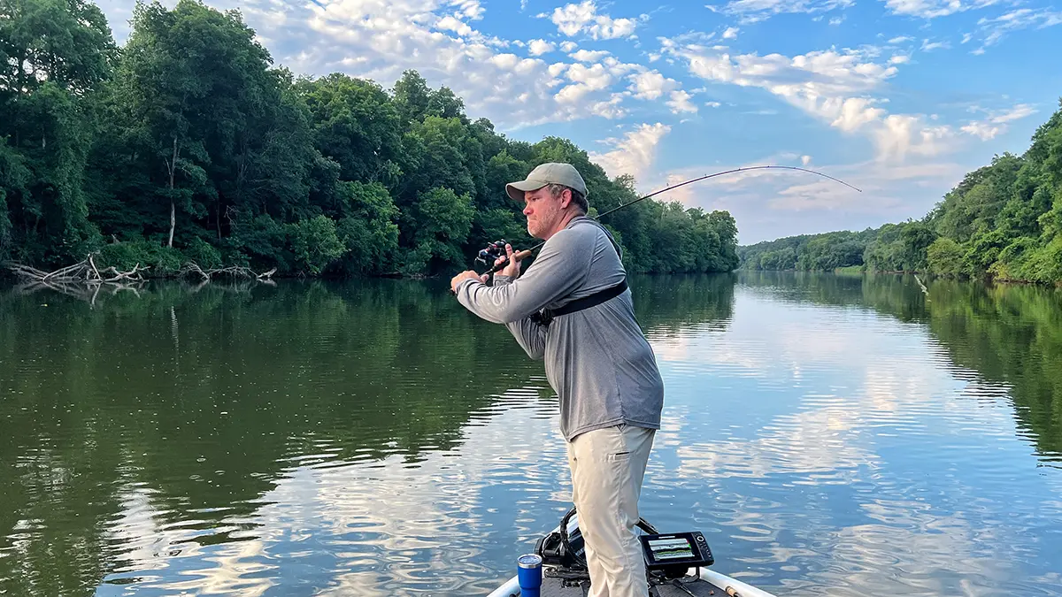 angler on a boat bringing st. croix mojo bass trigon rod back preparing to cast