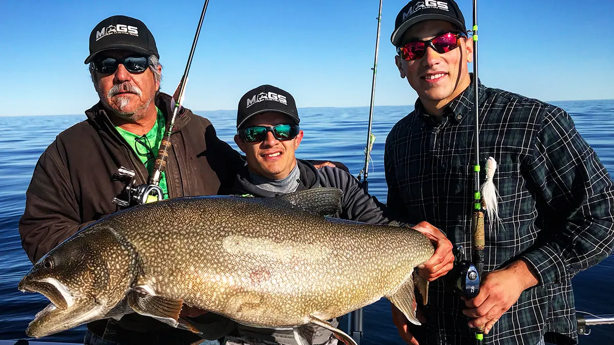 3 men holding giant lake trout