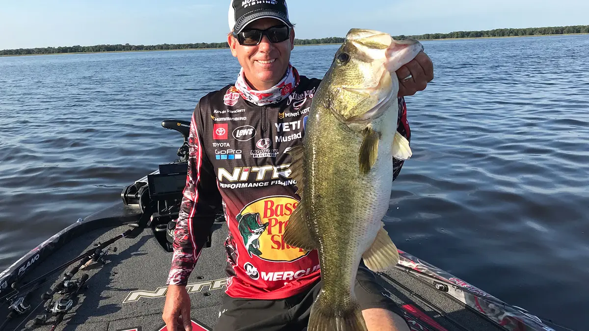 KVD on a boat holding a large bass