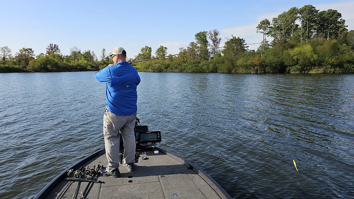 Keith Combs standing on bow of boat casting a Carolina rig