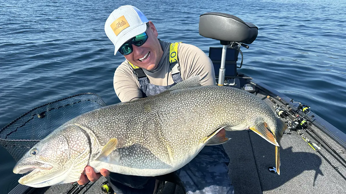 Kyle peterson holding a large lake trout on a boat