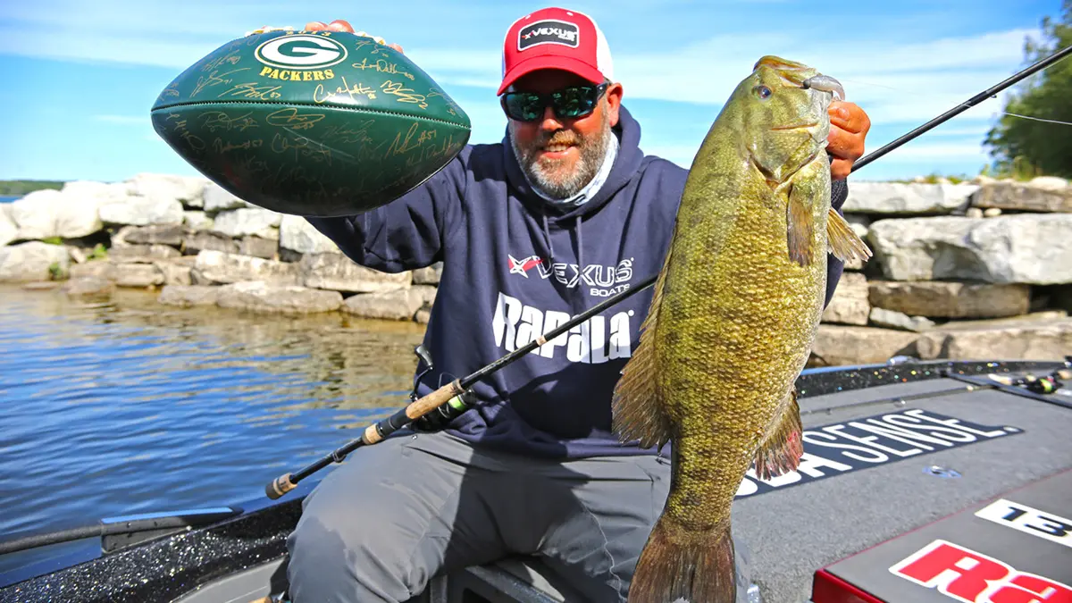 man holding football and big bass