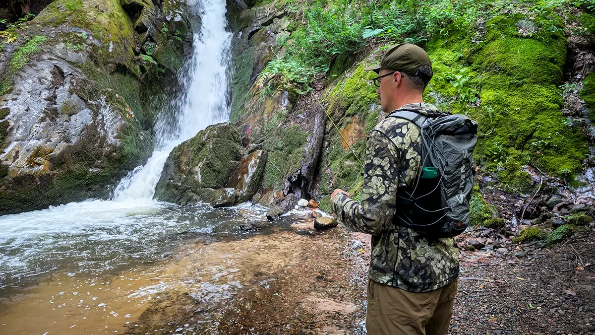 angler fishing waterfall