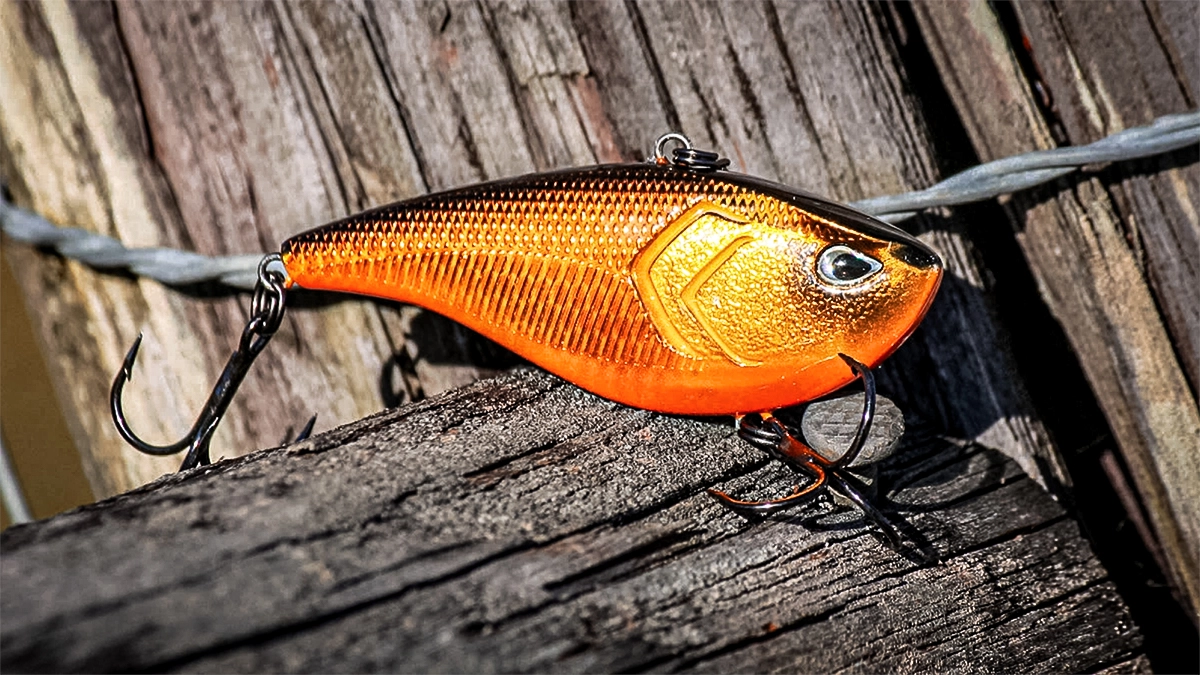 orange lipless crankbait on a wooden fence