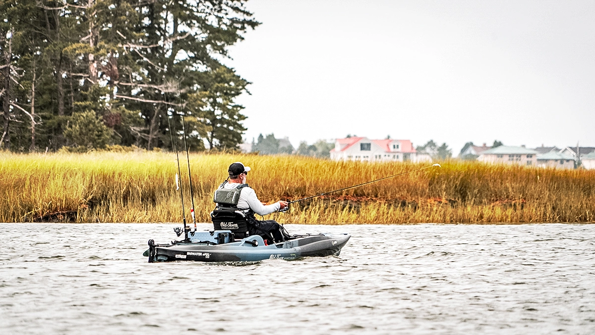 angler in old town sportsman kayak casting near shore