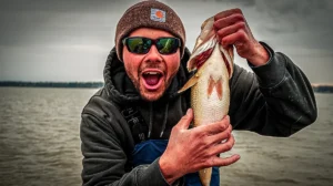 spring bass fishing man holding up a largemouth bass