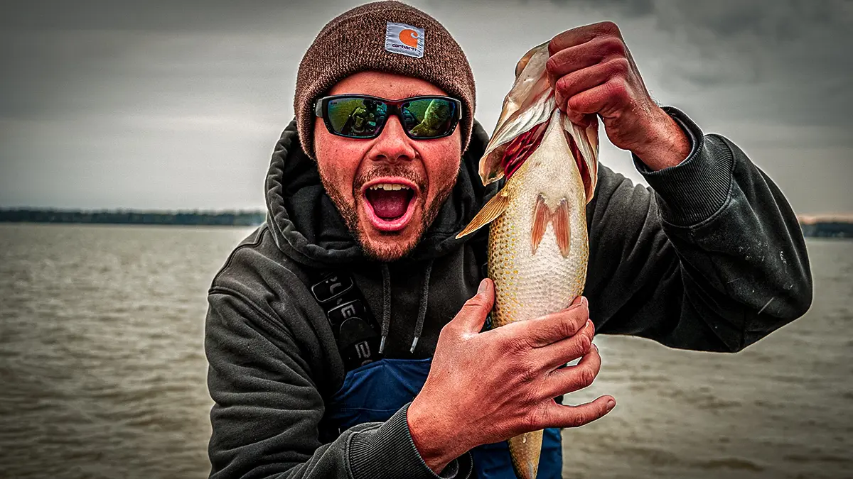 spring bass fishing man holding up a largemouth bass