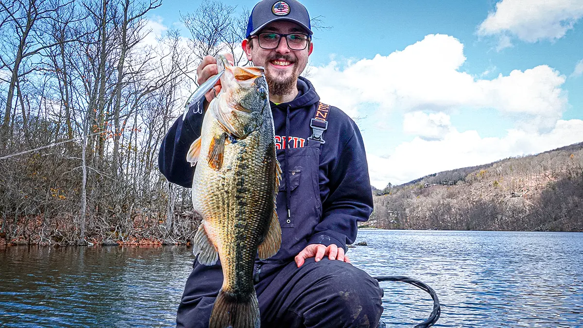 spring bass fishing man holding up a largemouth bass Caleb