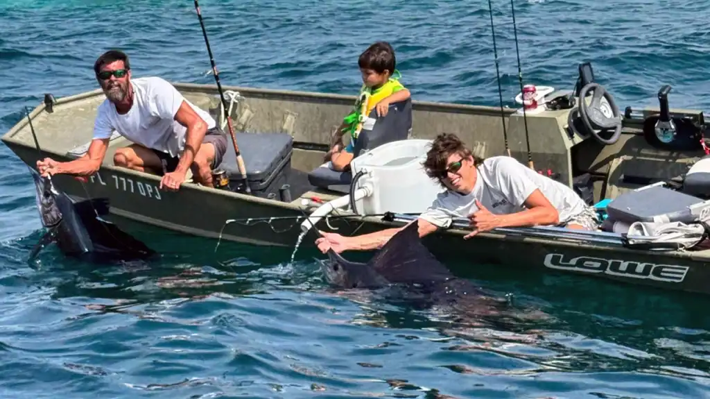 Father and two sons catch double header of sailfish from johnboat